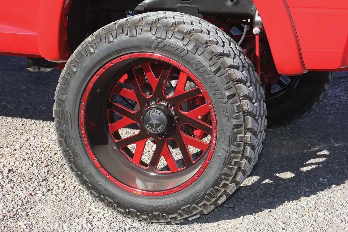 Rolling stock is a set of American Force 24x12 inch Whiskey SF8s with a custom red finish, wrapped in 38-inch tall Nitto Trail Grapplers.
