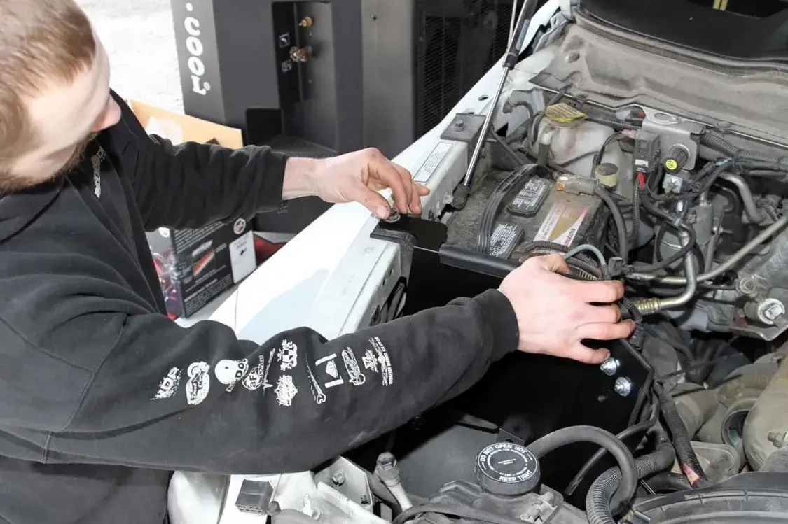 Grubb positions the heat shield and installs the mounting bolts