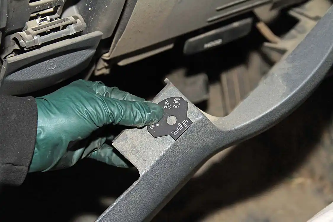 Meraz verifies the mounting location before drilling a hole in the plastic panel