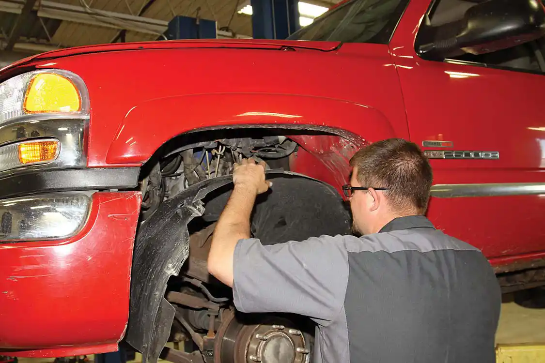 removing the plastic fender liner from each side, being careful not to damage the plastic retaining clips.