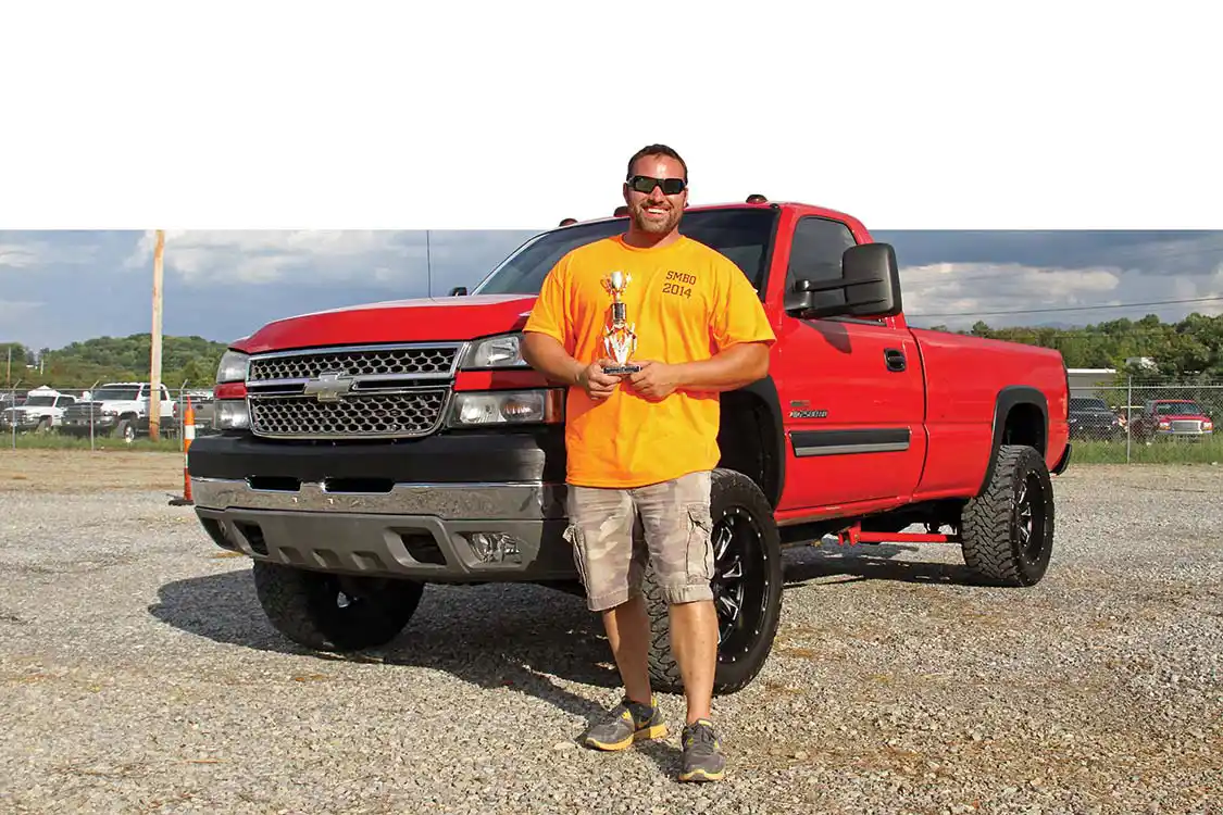 Jason Rial poses proudly with his Best GM truck trophy for his clean 2005 Chevy.