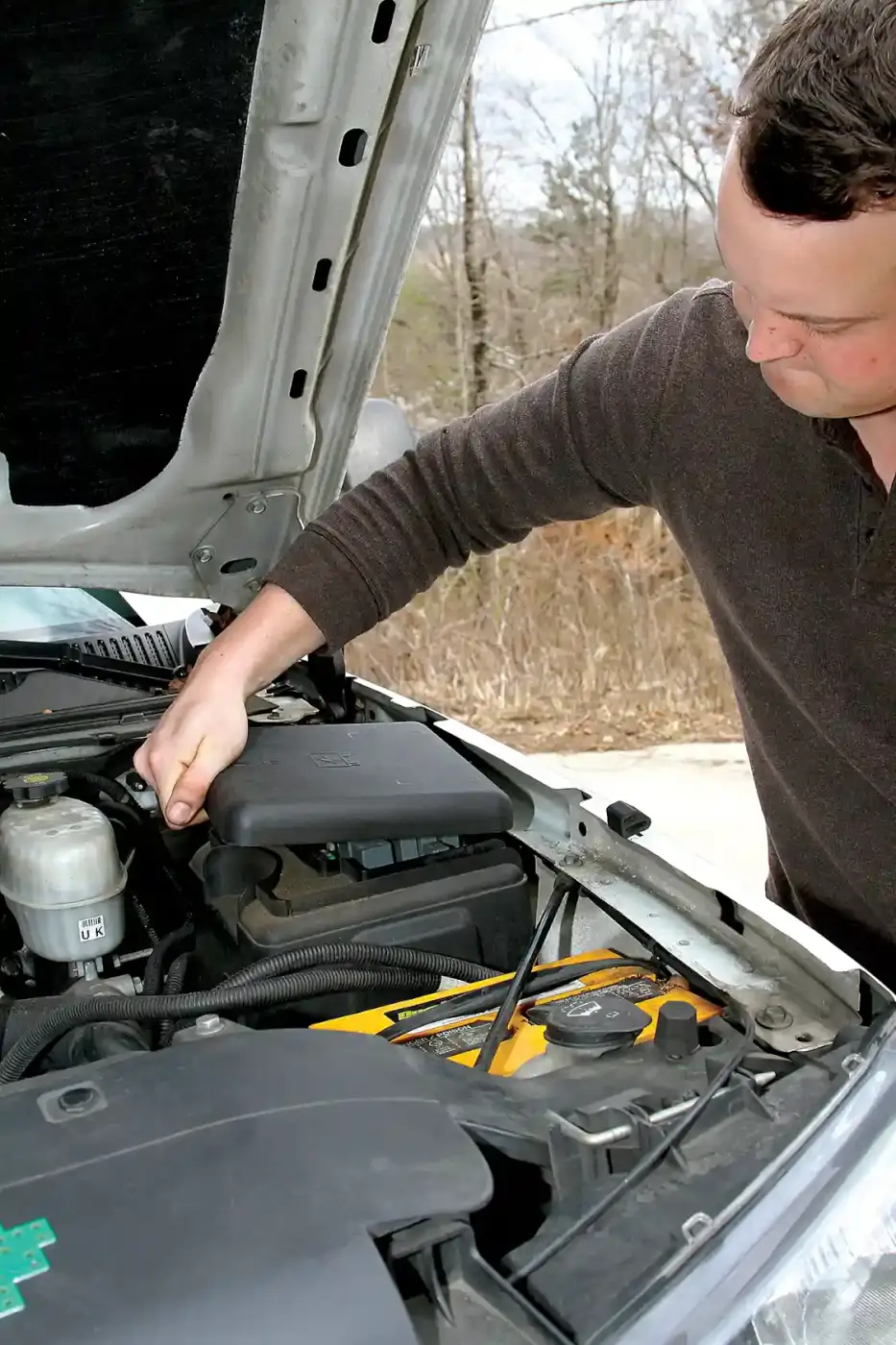 3. Clayton Putt starts the installation on his truck by lifting the hood and removing the fuse box lid to access the relays and fuses.