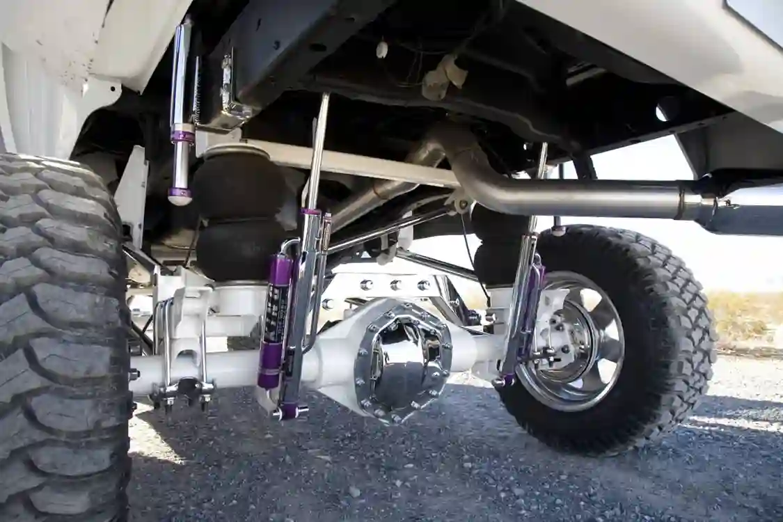 Here you see the rear shocks also from King. These are attached remote-reservoir units that work with the air bag rear suspension. Notice the chrome rear diff cover and brake backing plates. The axle is the original AAM 10.5 but it was powder coated white to match the body. Smith went show-quality all the way on this built.