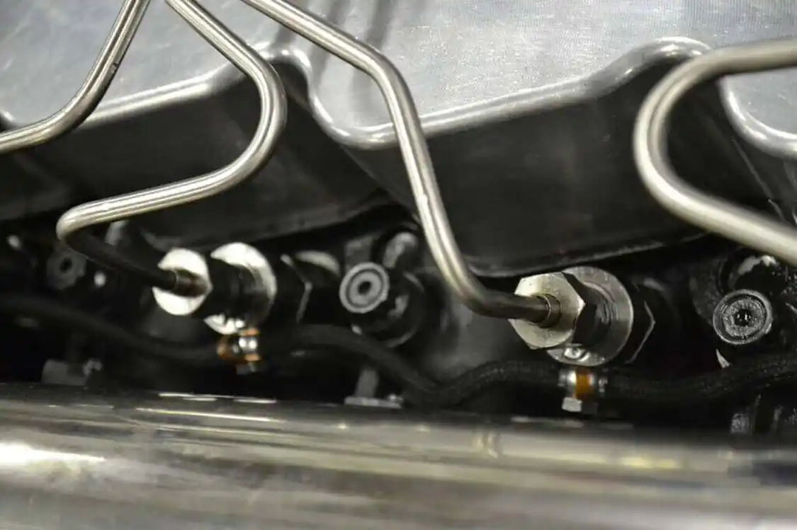 Oversize 0.120-inch stainless steel lines and 5x30 triple-feed injectors are also from Scheid's own shop, and provide the fuel needed for this type of power. Also visible are the 14mm head studs from <a href="https://arp-bolts.com/">ARP</a>, which keep the engine from having any head gasket issues.