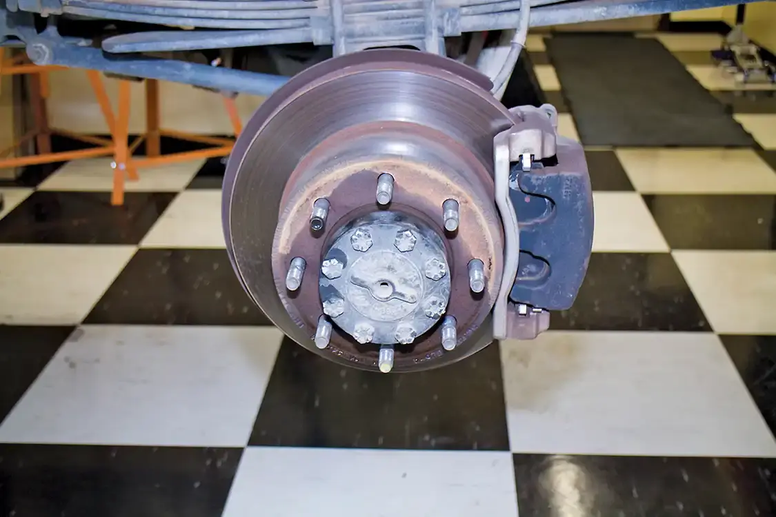 12. Here you see the stock rear-brake rotor and the 2-piston fixed caliper. The drum-style parking brake is also here as a set of shoes inside the rear rotor hat.