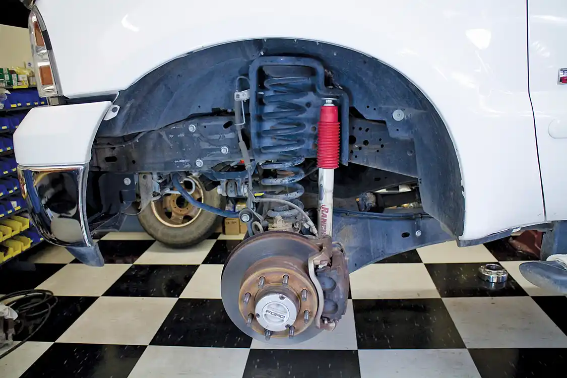 1. The stock front brake setup is seen here. The caliper, pads and rotor are removed per the service manual and set aside. Once you’ve completed your Wilwood upgrade, these parts are not needed. 
