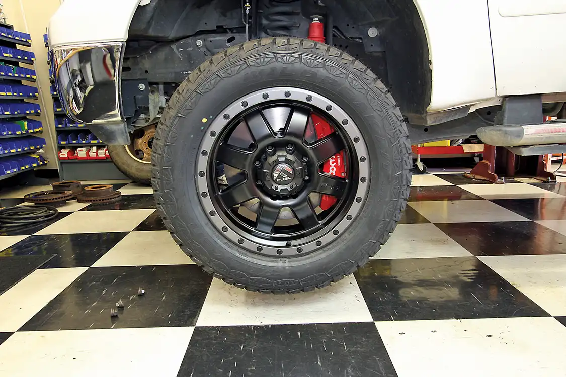 17. For this install, the stock wheels were too small. Yep, those factory-installed 18s just won’t fit the bigger brakes. A set of Fuel 20-inch wheels where fitted with Falken Wild Peak, LT205/55F20 tires in load range E. Note that aftermarket wheels must be of the proper offset and may require new lug nuts—ours did. Also, the center must allow for the use of manual locking hubs; on this wheel, the center cap hat can be removed to better match the rear or not used at all up front. See here, the cap with the cap hat in place before removal.