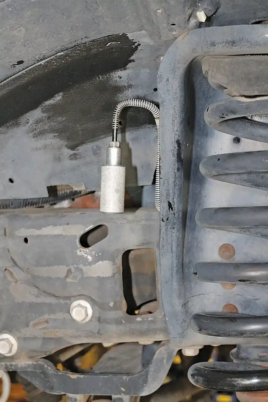 2. The stock calipers can be removed with the flexible line attached. The Wilwood kit comes with new braided stainless steel lines. Here you see a line cap in place to prevent brake fluid from running out onto the floor. This prevents a mess and makes bleeding your new brakes easier too, as the system will only have a little air in it at the caliper end. 