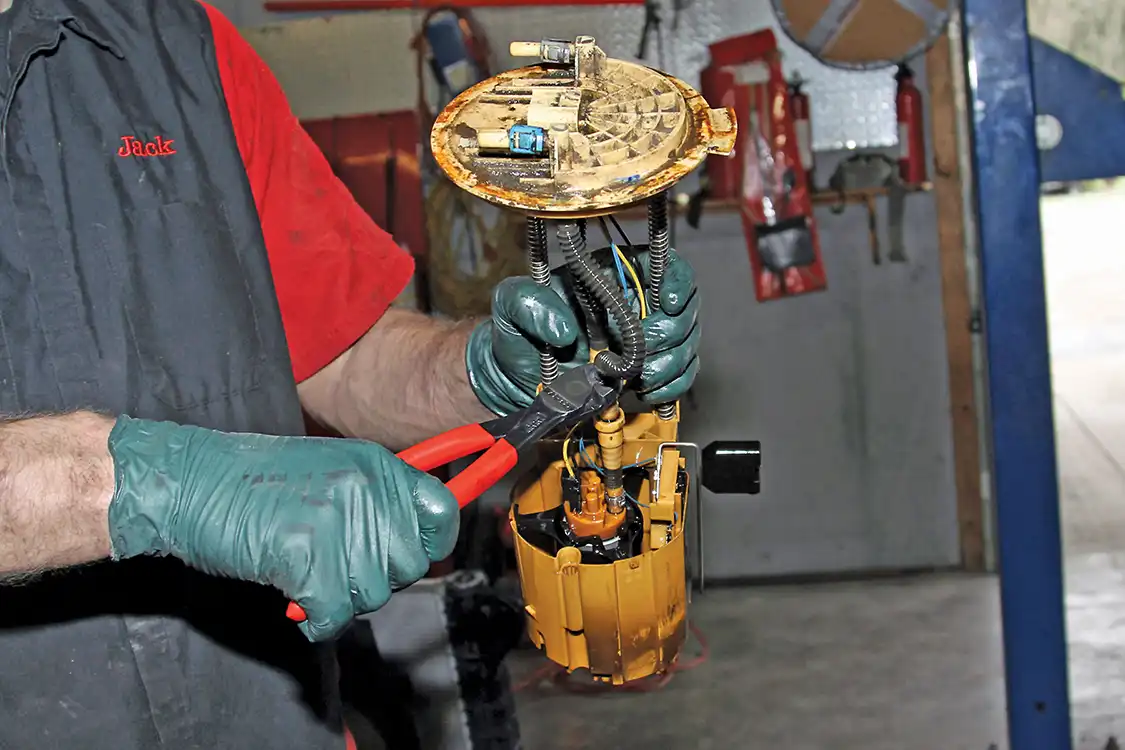 19. With the factory pump assembly in hand, Grubb cut the original feed line from the pump so that the fitting may be used as the return line from the AirDog system.