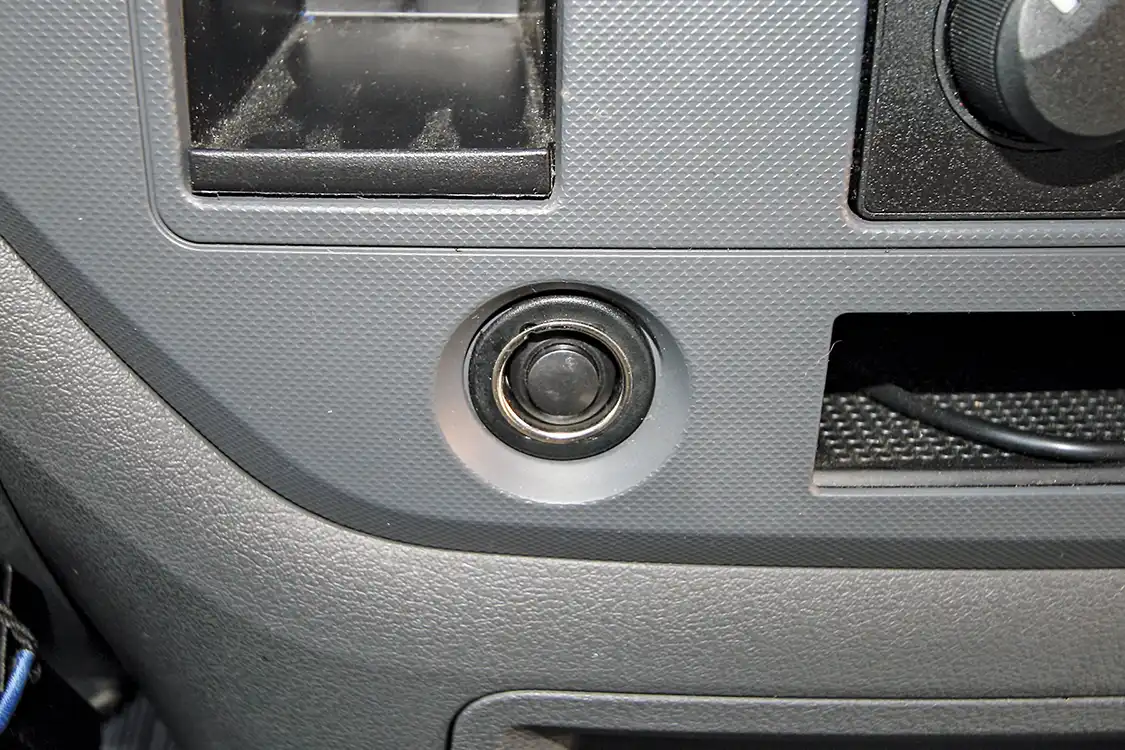 18. Since Daniel, the owner of the 2500 Dodge, had two cigarette lighter plugs, he decided to sacrifice one for a hidden air horn button. The included button fit nicely in the hole and some quick modifications to the OEM cigarette lighter meant, with the cap on, nobody knew that nearly 160 decibels of train horn were lurking underneath.