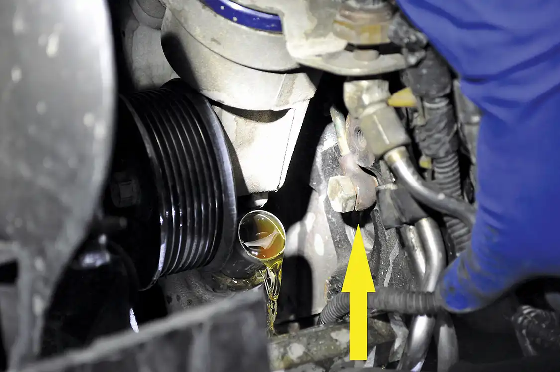 1. After removing the intake, upper radiator hose, and both intercooler tubes to gain access to the front of each head, Bud's Diesel's Hector Lezama removed this banjo fitting and bolt. The banjo fitting is what supplies each head with fuel.