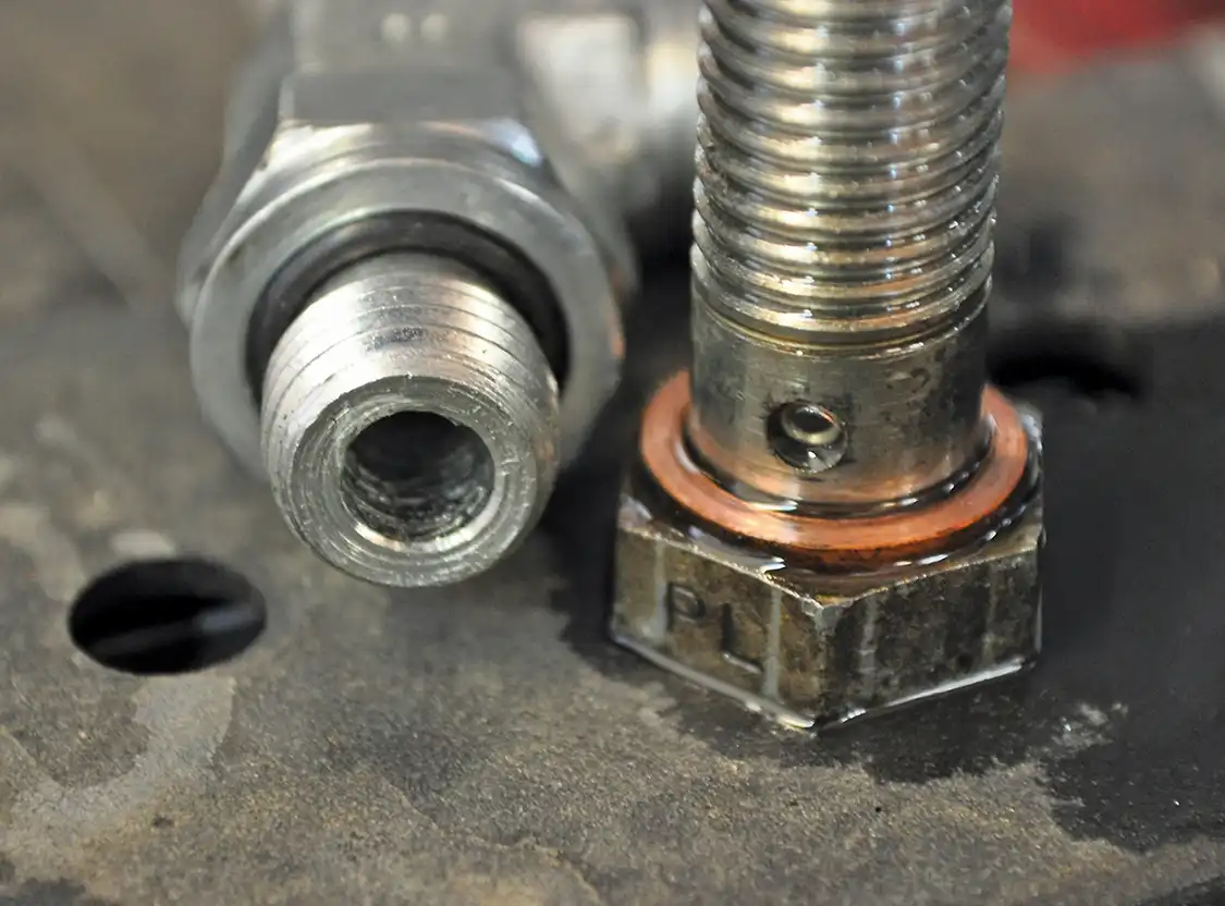 2. The factory systema feeds fuel to the heads through lines into two small holes in the banjo bolt (right). The new HSP system will flow much more fuel directly into each head through this new fitting (left).