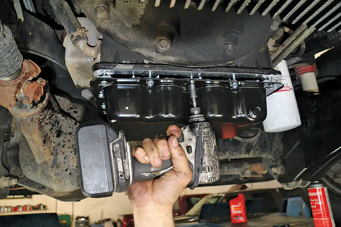 10. The new steel oil pan is reinstalled on the engine after cleaning the mounting surface of the block with an appropriate solvent to ensure a clean seal. The bolts are first lightly snugged down and then tightened to spec.