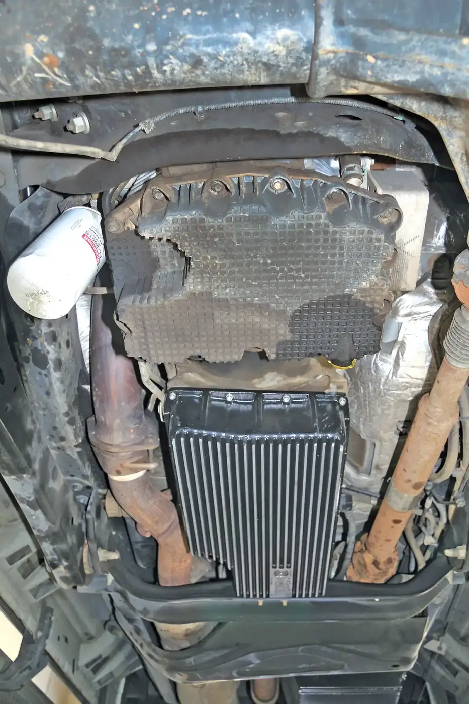 2. In this view, you can see the oil pan drain leak area (right), and a spot from oil dripping off the filter (left). This filter drip is likely from past oil changes, as filter leaking on the 6.7L is usually only reported when the filters are not properly installed.