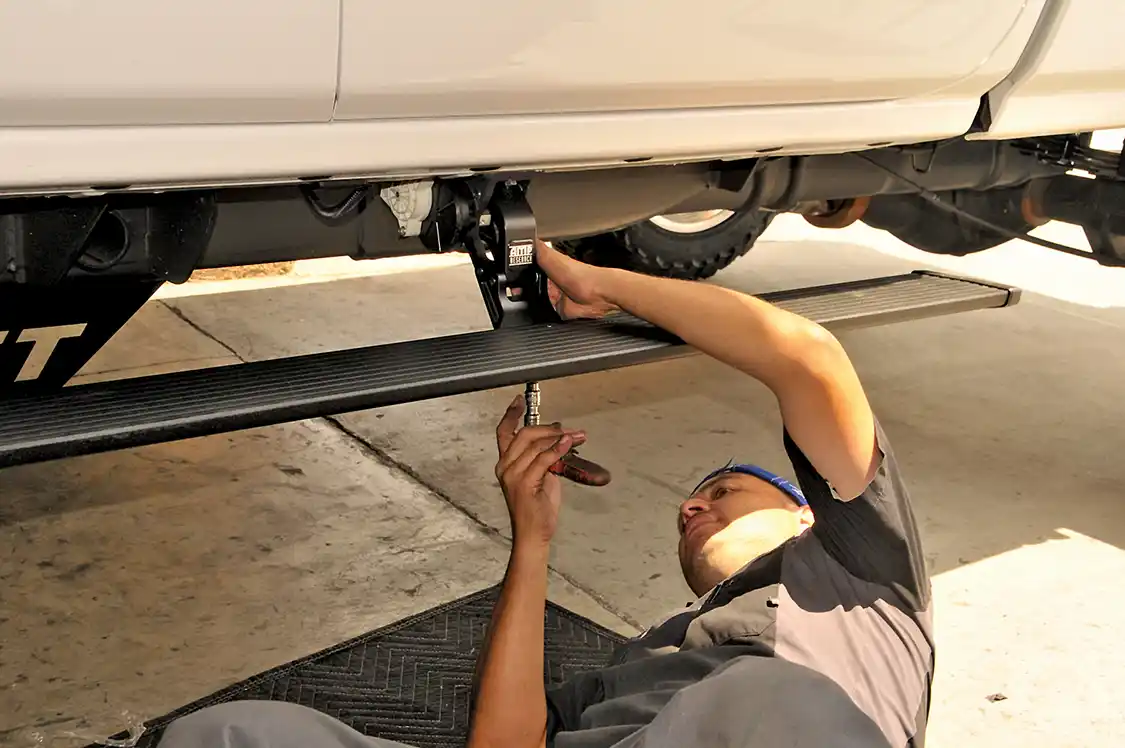 23. After both hinges are attached to the truck, the running boards are moved into position on the hinges. The Amp Research steps come with a wiring harness that makes the install pretty easy. You no longer have to find a hot wire to splice into-- just plug it into the OBDII port and you are done.