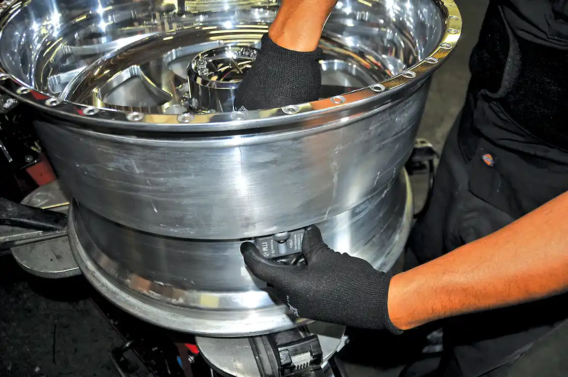 24. A set of American Force wheels were next on the list of mods. The American Force wheels needed to be outfitted with the GMC's factory-installed Tire Pressure Monitoring System sensor so no codes will get thrown. It simply bolted into the Schrader valve hole.
