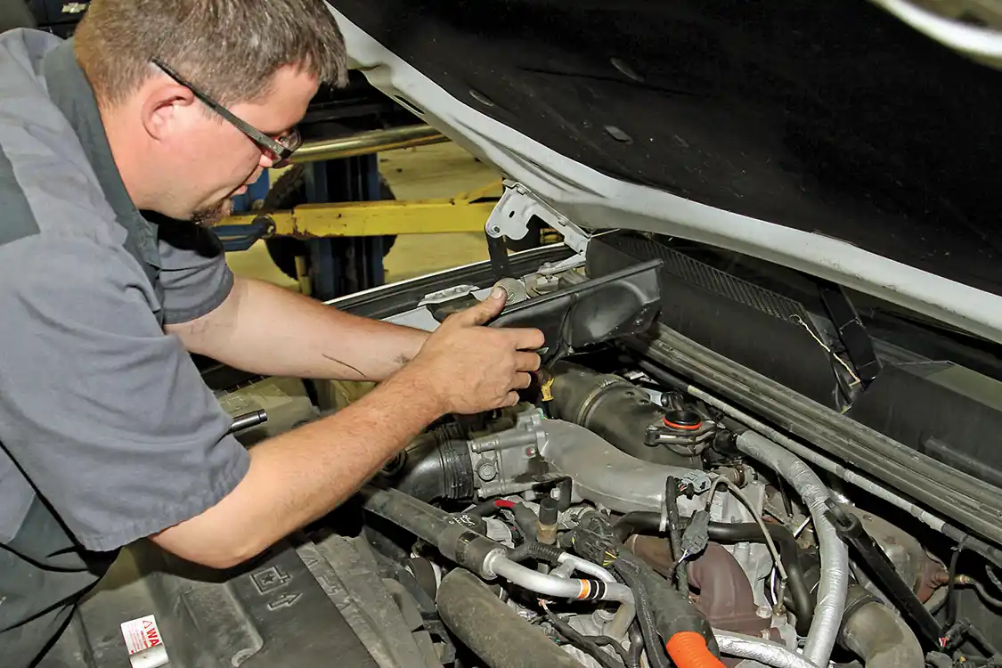 3. Jake Phaff starts the installation by removing the bolts securing the plastic resonator to the turbo inlet. Then the resonator can be lifted off the turbo inlet.