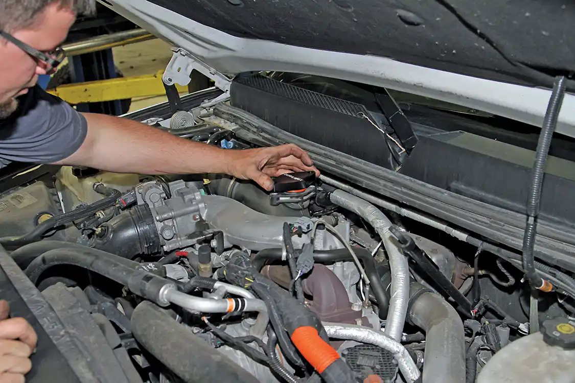 5. Then he aligns and presses the delete plate into position on top of the turbo inlet.