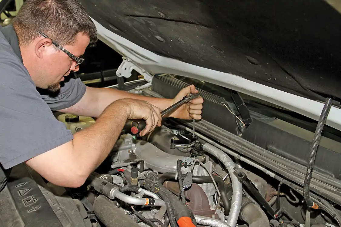 6. Phaff tightens the mounting bolts to the plate. Be sure not to over-tighten them as they are running into a plastic intake tube and the O-ring handles the seal, not the torque on the bolts.