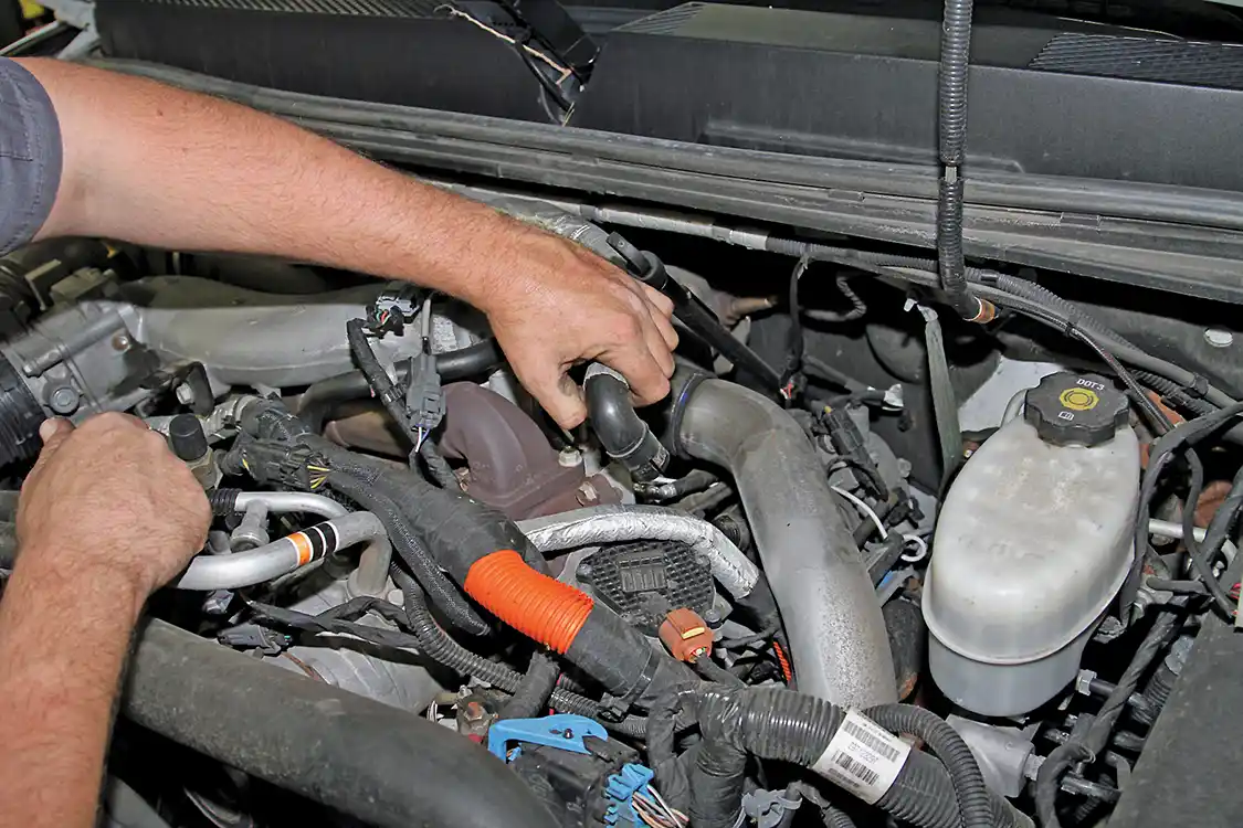 9. After he removed the clamp, the technician pulled the end of the PCV hose off the fitting as shown.