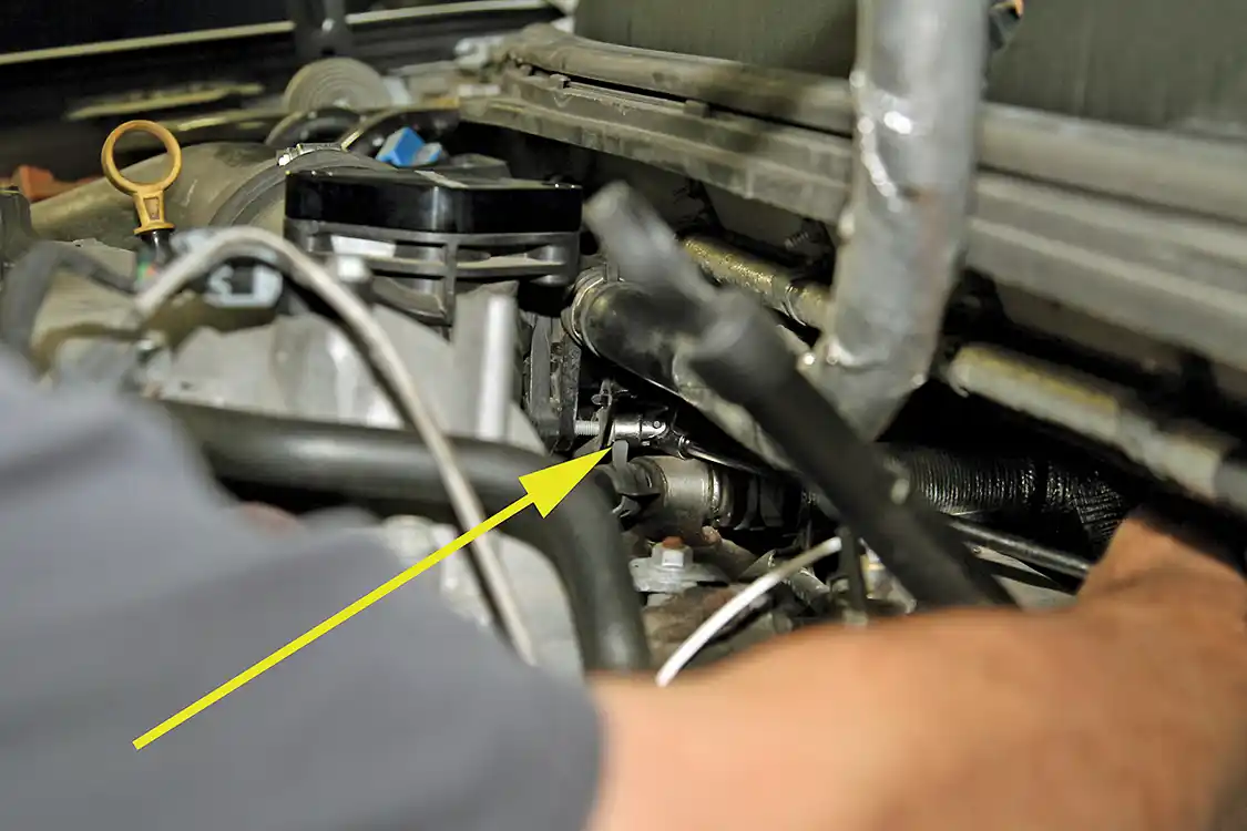 12. But, the bottom bolt is much more difficult to access and get a wrench on. Use a U-joint socket (see arrow) and long extension along with a lot of patience to loosen and remove the lower mounting bolt.