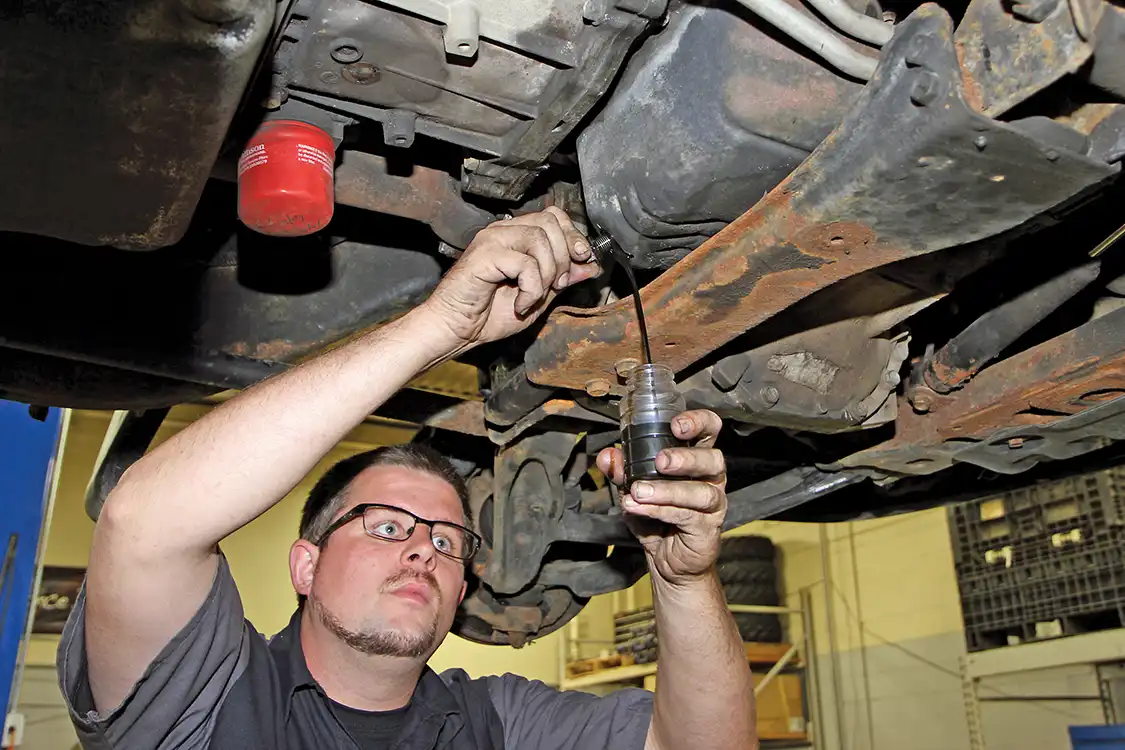 2. On the first truck, Jake Phaff drained the sample directly from the oil pan on the truck. This method is easy if you are draining the oil but can be difficult and messy if you’re just taking a small sample.