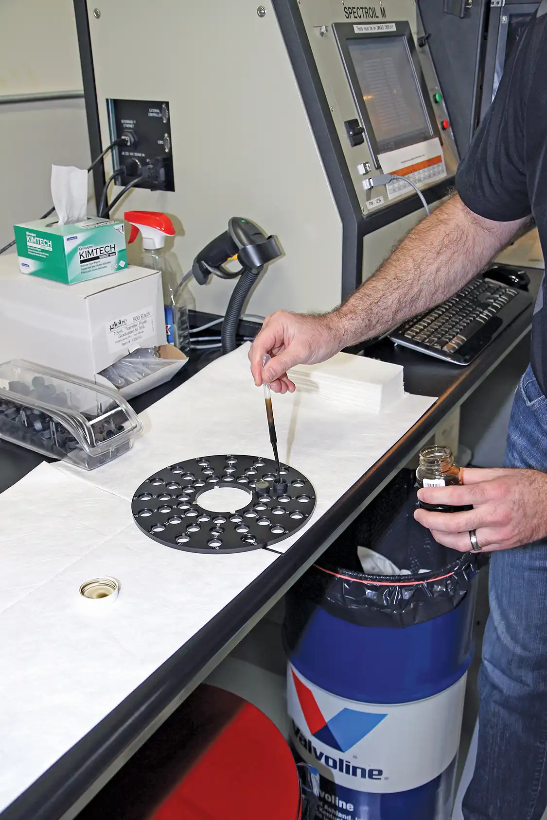 12. Rainey uses a clean pipet at each test station to prevent sample contamination. Here, he fills the sample cups to test our two samples in the Spectrometer; as you can see, the tray can hold up to 48 individual test samples per run.
