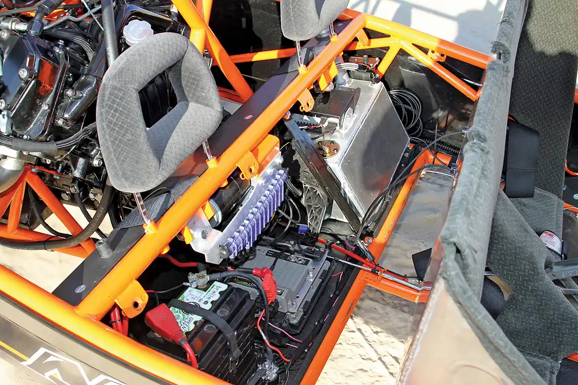 Folding the aluminum seat forward, you can see the storage compartment that contains the battery, ECU, Racepack Smartwire controller, electronic throttle, fuel tank and radio system.