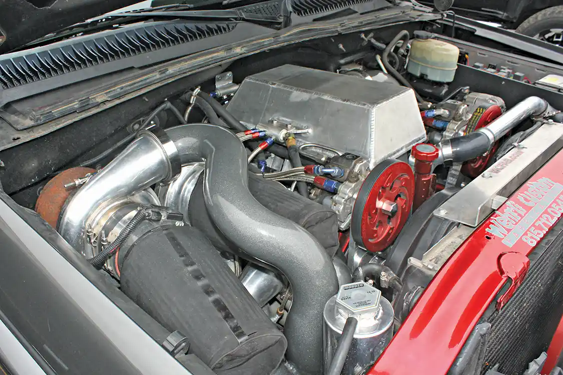 It takes a keen eye, but looking closely you can see not two but three S400 turbochargers hanging off the side of that Duramax engine. Owned and built by Jason Wherli of <a href="https://www.wcfab.com/">Wherli Fabrication</a>, this LB7 Duramax has a host of custom parts that have helped push it to be one of the highest horsepower trucks to ever cross the DuramaxTuner chassis dyno.