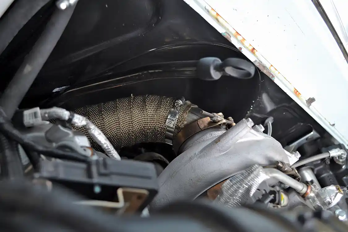 Normally a turbo downpipe is a pretty tight squeeze in a swap, but the engine bay of the Apache actually had a lot of room. Bill made up a 4-inch downpipe, which then attaches to a 4-inch exhaust that runs the length of the truck.