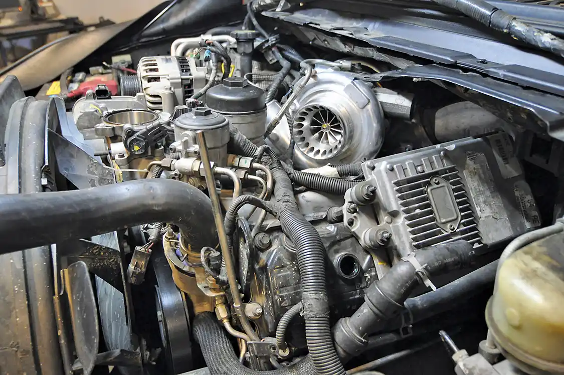 2. A multitude of things need to be removed to access the oil cooler. The first thing Bullet Proof Diesel Technician Delwin Wamsley did was remove the grille to protect it from scratches. Wamsley then started draining the coolant, removed both intercooler tubes, air intake, Degas bottle, alternator and the FICM (still installed in this photo).