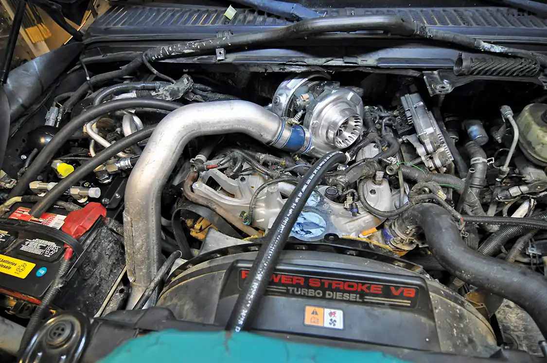 17/18. Before reinstalling the turbo, Wamsley hooked up a coolant line that would be inaccessible after the turbo was in. He then installed the turbo and began running the remaining three out of four lines from the Bullet Proof manifold to where the other end of the kit, the factory oil cooler and Bullet Proof adaptor assembly would be mounted.