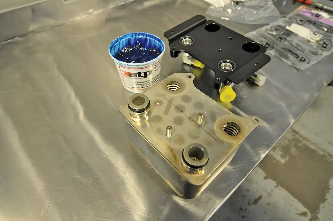 21. Wamsley then began to mount a new factory Ford oil cooler to the Bullet Proof Adaptor using new O-ring gaskets with a bit of assembly lube to aide in instillation and to ensure they seal correctly.