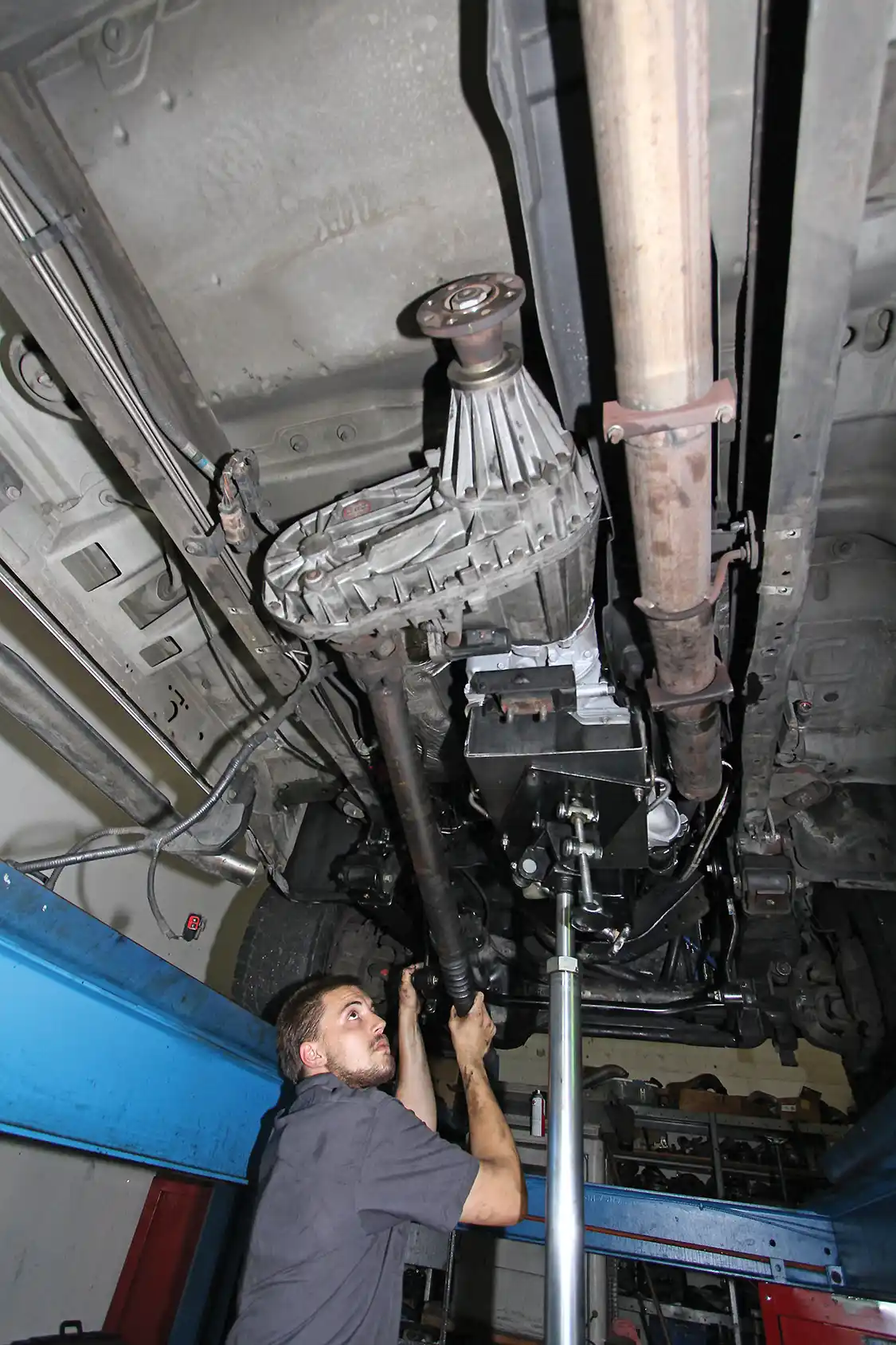 10. The transmission and transfer case assembly is lifted into the truck with the aid of a transmission jack. The unit is bolted onto the motor and the front driveshaft is bolted to the front differential yoke. 