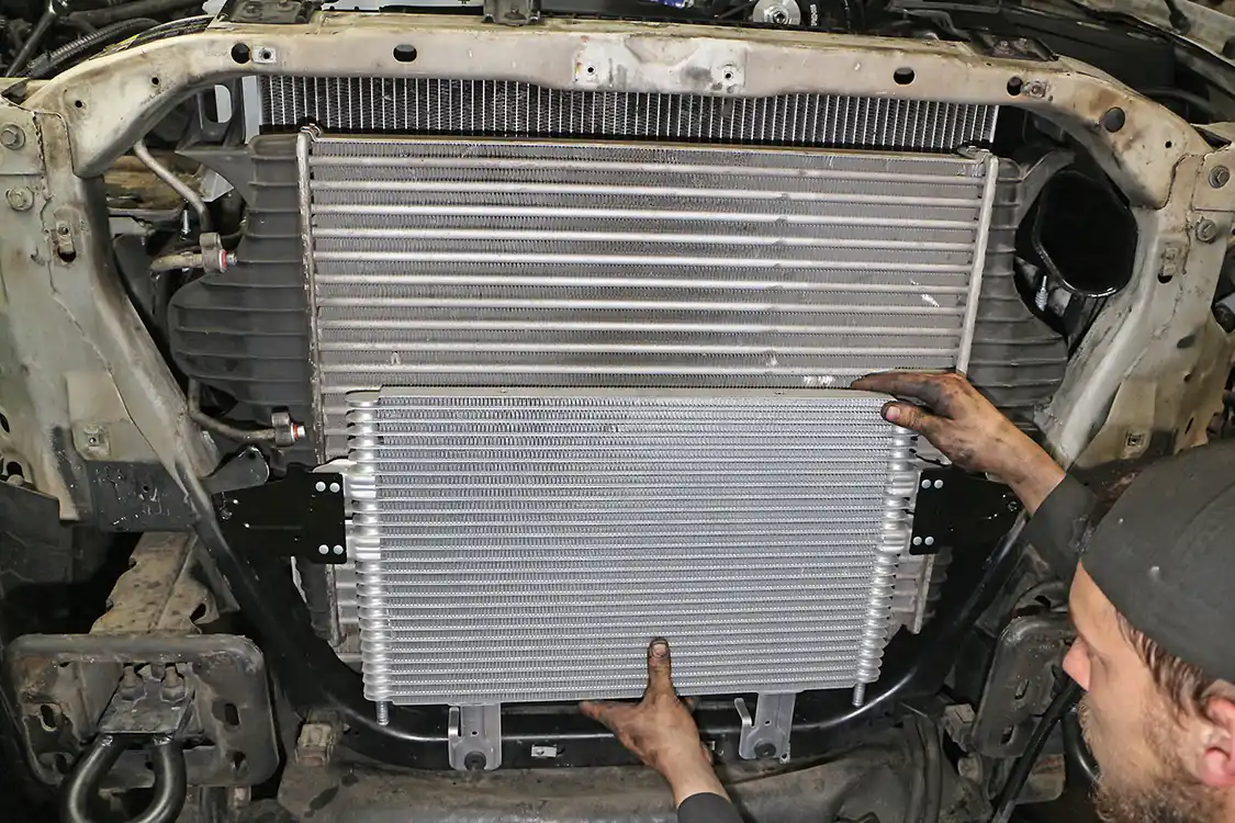 14. If your truck has had the automatic transmission fail catastrophically, a new oil cooler is recommended. This and flushing the hard lines will keep metal shavings from the old system from contaminating your new setup. Here you see a larger transmission oil cooler from a 6.0L Ford being installed. (The June 2015 issue of Diesel World has more on this upgrade.)