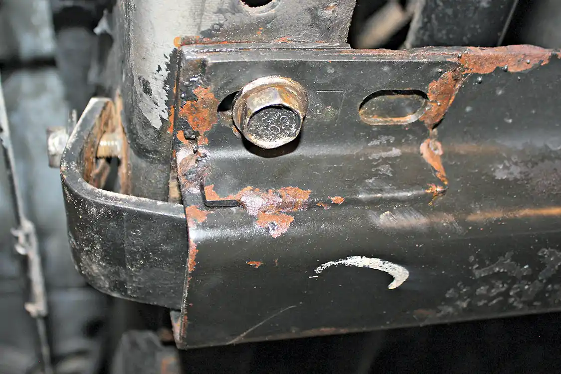 4. After placing a floor jack under the transmission to support its weight, the transmission cross member can be taken out. It is bolted to the frame rails with four large 18mm bolts, two on each side. The outer L-shaped bracket will need to be removed as well.