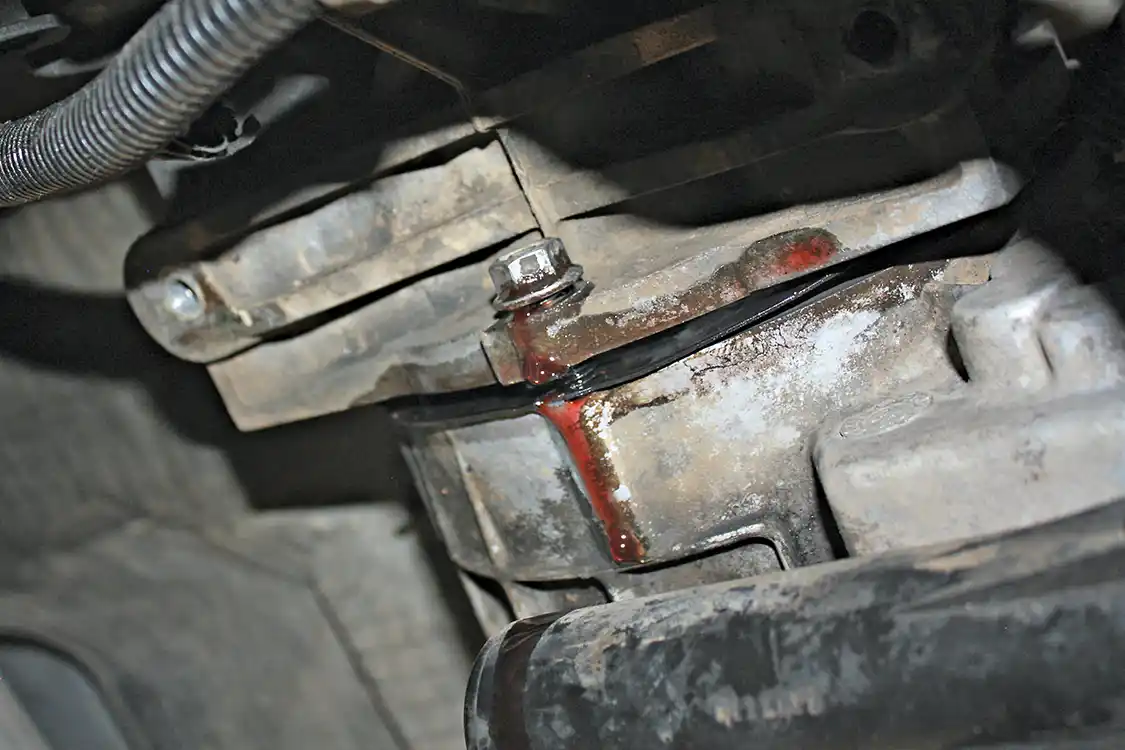 7. The last step is loosening and removing the six 15mm nuts that hold the transfer case tight to the back of the transmission. While the transfer case had previously been drained, you will still get some fluid from this once the seal of the gasket is broken, so be prepared.
