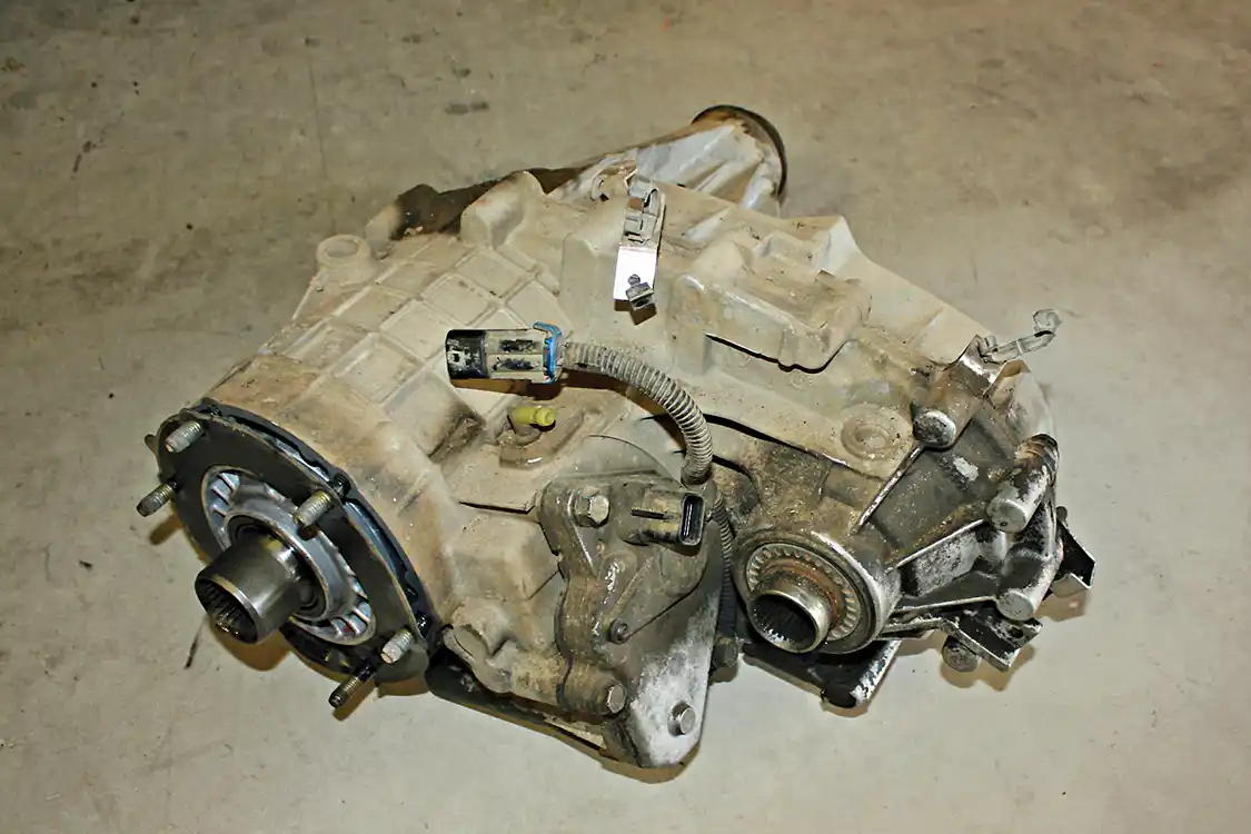 8. With the help of a friend, the transfer case can then be slid back far enough to clear the mounting studs. It will need to be tipped up at an angle to slide it down past the rearward cross member. You’ll want to discard the old front gasket as a new one is supplied with the new PPE Pump Rub Kit.