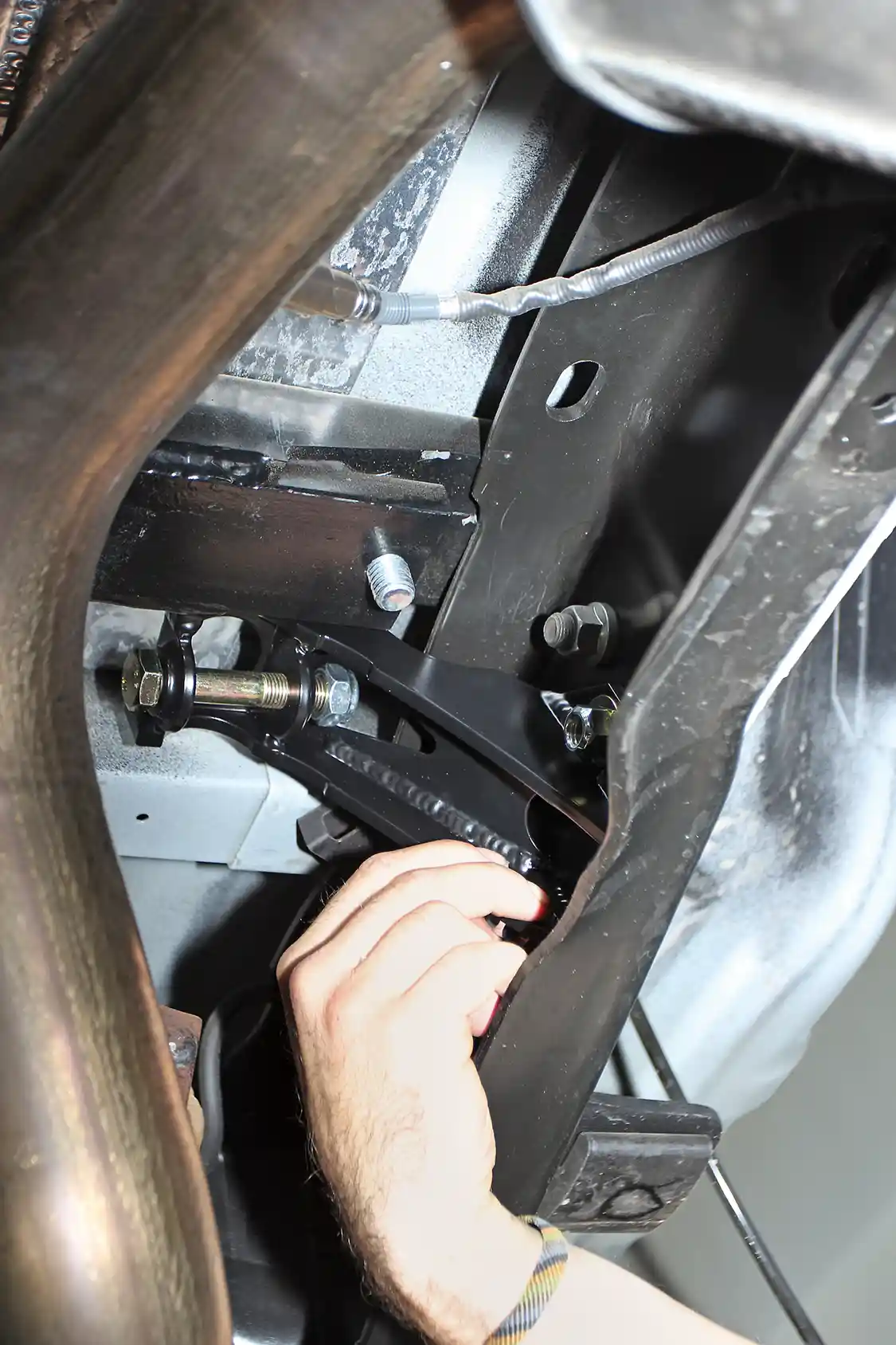 14. Seen here is one of the two new rear shock mounts, now bolted to the frame using the OEM brackets’ rivet holes.