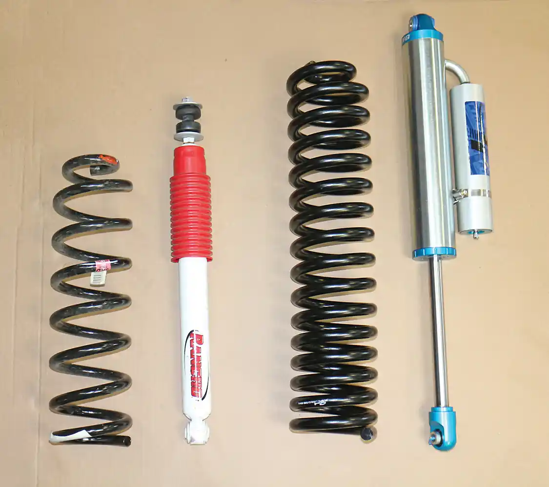 4. The OEM front spring and shock (L) are seen here, compared to the longer Carli springs and remote reservoir shocks.