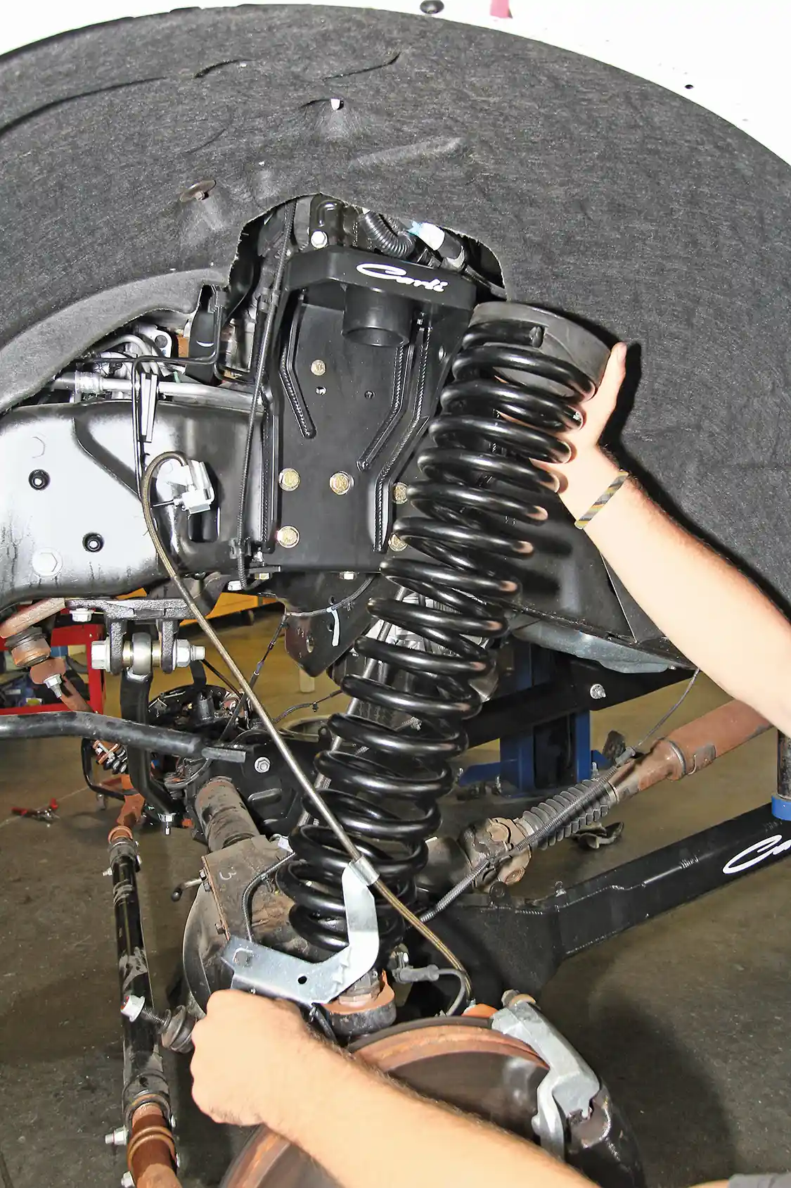 6. Longer, braided stainless steel brake lines are installed and then the new, longer front coils are put in place.