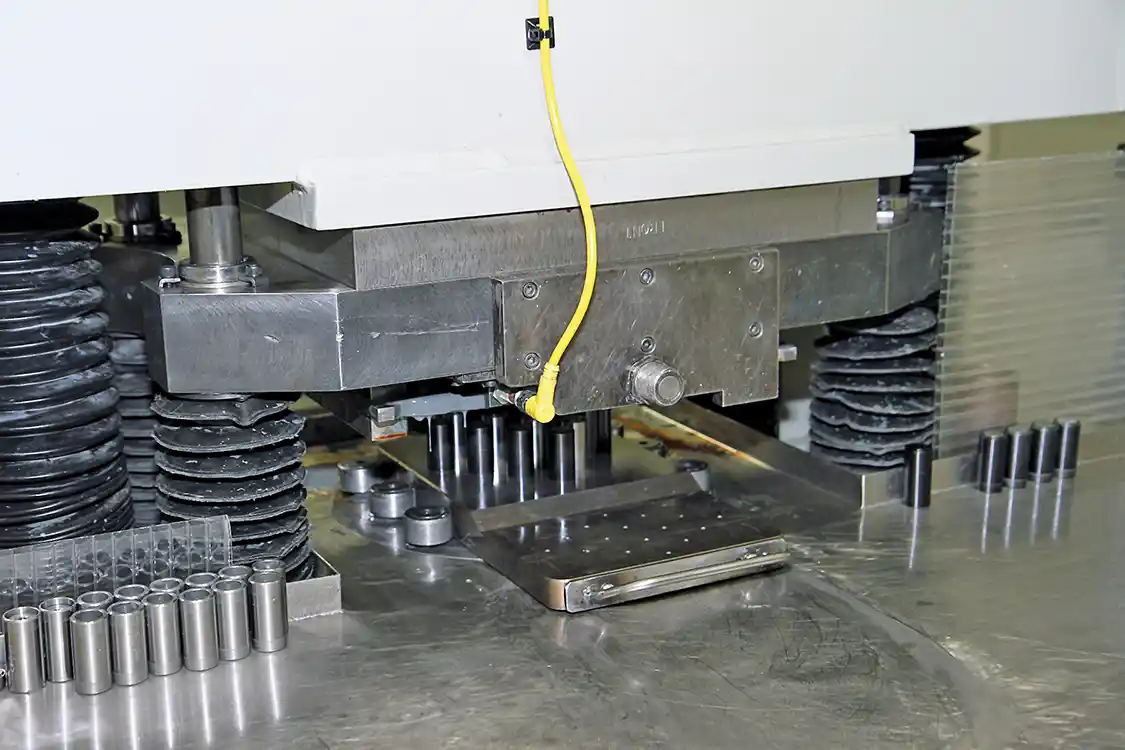 9. The fixture and nozzles are slid under the press where the abrasive media is forced through the nozzles under a great deal of pressure to enlarge and smooth the path of fuel flow through the nozzle.