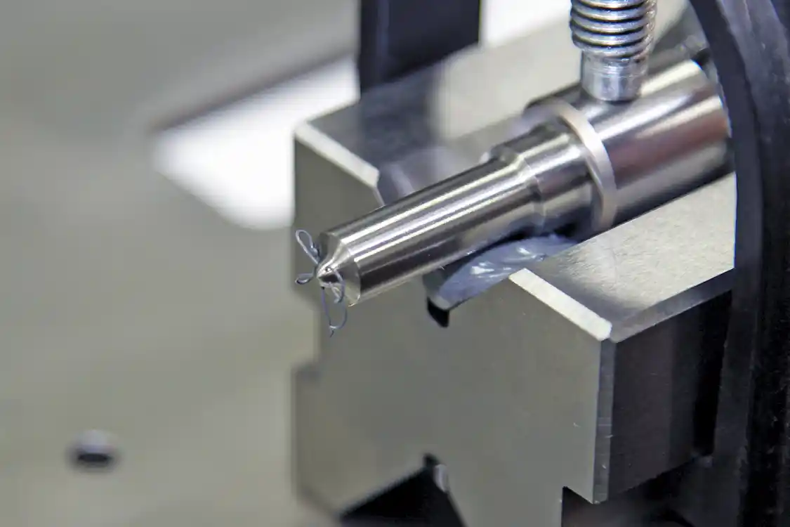 12. To simulate the part of the AFM process that we could not see, Spoolstra loaded a nozzle into a vice and then pushed the abrasive media through the nozzle by hand showing the trails of media from each of the nozzle’s five holes.