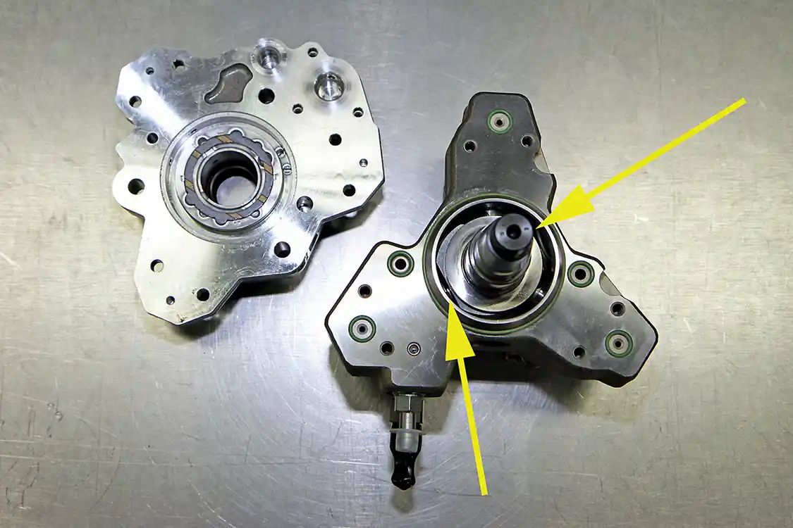 15. Looking at the inside of a CP3 pump, you can see the pump shaft (arrow on the right side) while the arrow to the left side of the shaft points to one of the cam followers (buckets) that ride between the polygon and the plungers in each of the three bores which pump the fuel to build the tremendous pressure needed for the common-rail fuel system to function properly.