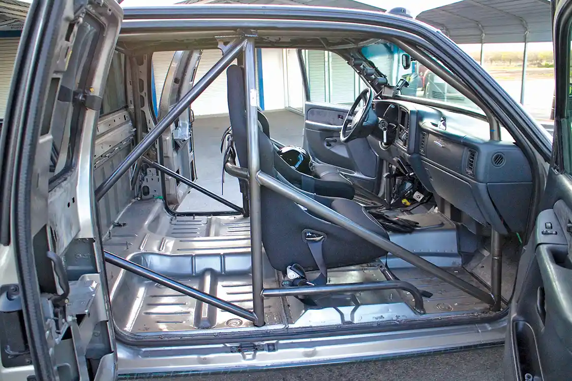 To lighten the truck, the interior was stripped out. A cage from <a href="https://rollover-motorsports.com/">Rollover Motorsports</a> was installed for safety. The stock seats were replaced with a pair of <a href="https://corbeau.com/">Corbeau</a> seats with 5-point belts.