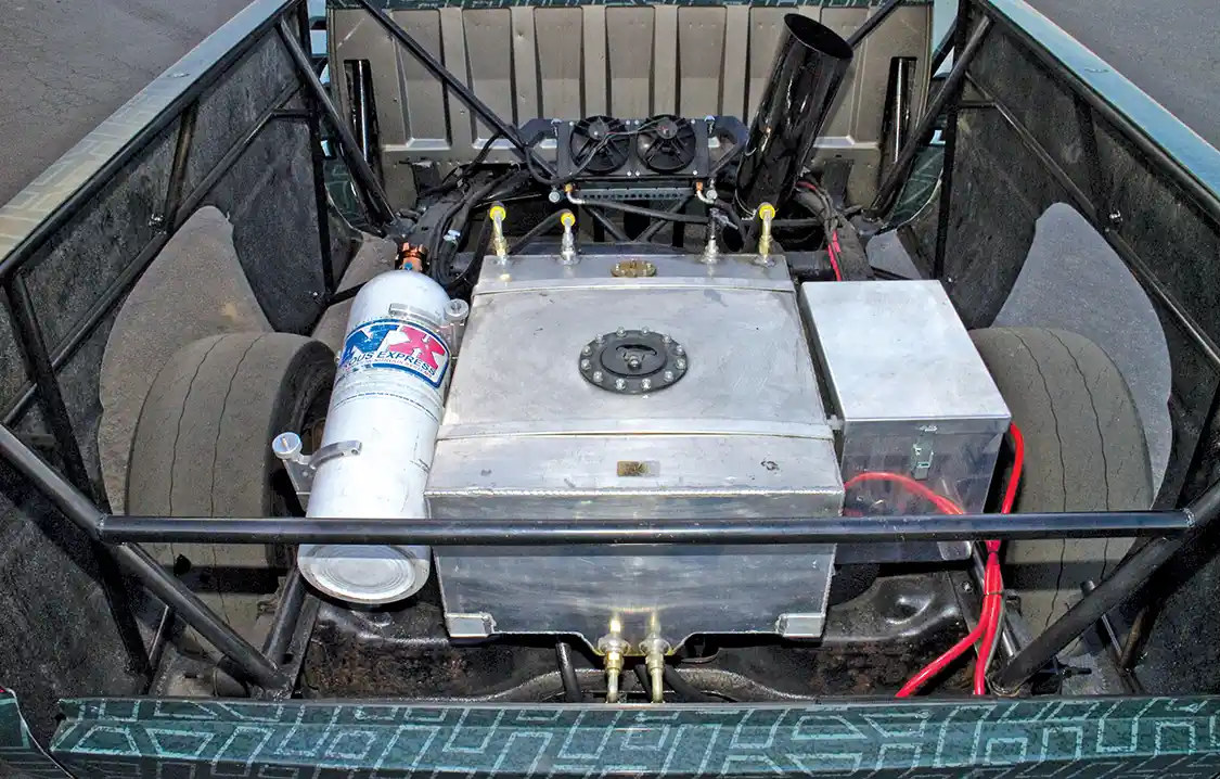 Between the frame rails, in the back of what was the bed space, you’ll find a 15-gallon fuel cell, nitrous tank, transmission cooler with fan and the battery box. This weight is strategically placed over the rear axle to improve traction.