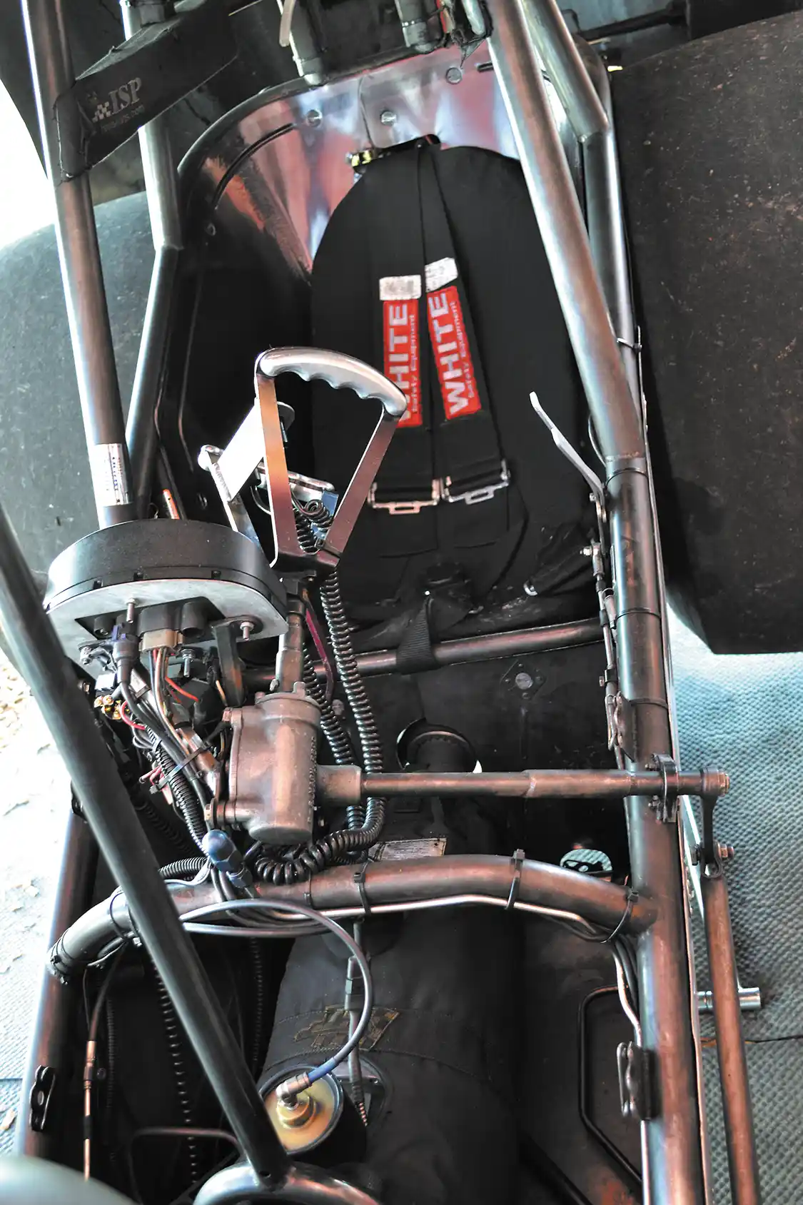 John's 6-second office is quite sparse, with only the bare essentials needed to go a quarter mile at a time. The fit inside the Funny Car Cage is a tight fit, and buttons or handles for shifting, boost management, and to deploy the parachutes are all close within reach.