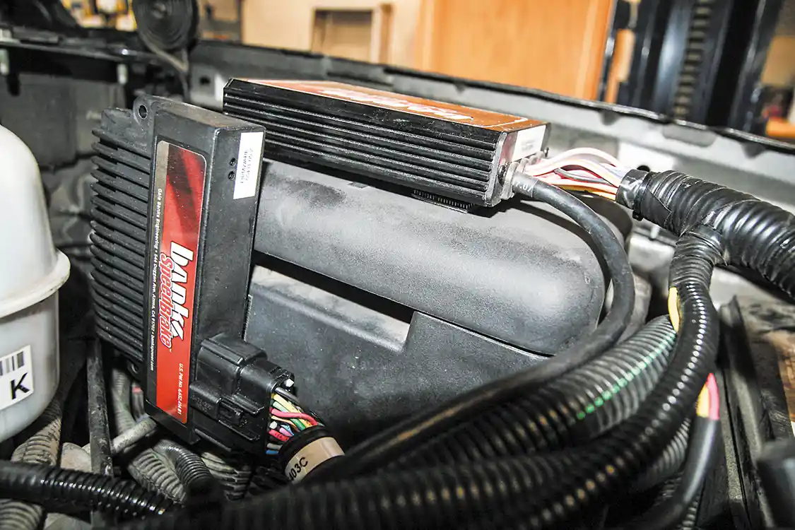 17. Next we move under the hood to mount the SpeedBrake with the supplied Velcro adhesive strips to the fuse box. Note that we’d already mounted the Banks iQ on the top of the box, so we secured the SpeedBrake to the side.