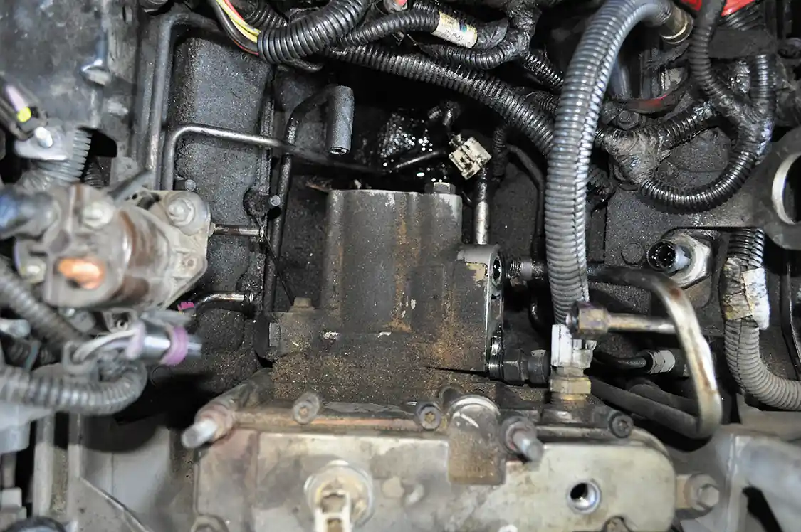 4. With the filter housing out of the way, we can now see the HPOP between the two heads. Here you can see we’ve already unbolted its in-and-out oil lines.