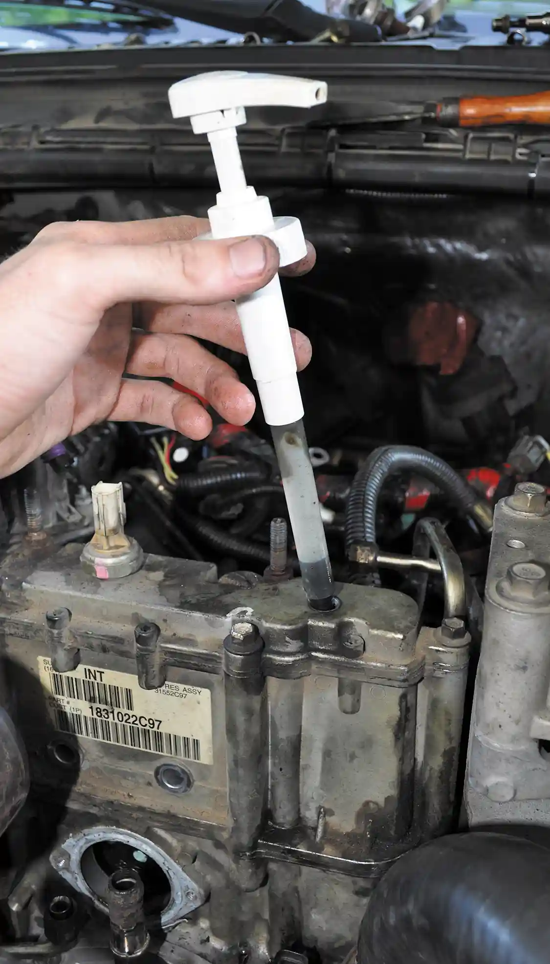 5. Before removing the oil lines and unbolting the HPOP, we drained its reservoir of oil using a cleaned out hand pump from a <a href="https://www.gojo.com/en/">GoJo</a> bottle to prevent a large mess of used oil. A more professional fluid evacuation tool would work just as well.